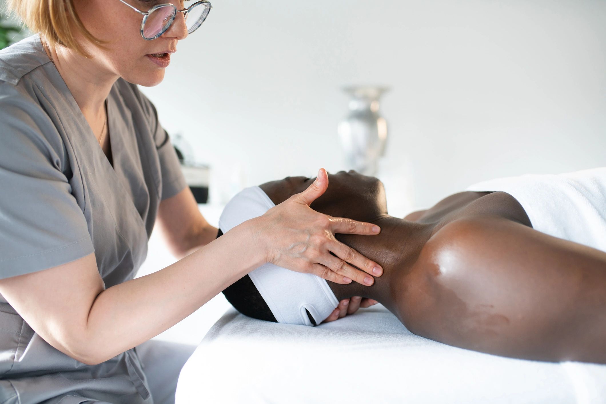 Professional spa therapist giving a facial massage to a relaxed client